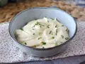 Mayonnaise sans huile crémeuse, garnie de ciboulette fraîche, dans un bol en céramique. Parfait pour un repas léger.