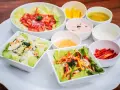 Assortiment de salades colorées avec plusieurs options de sauce pour salade, dont une rose et une verte.