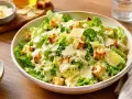 Une généreuse salade César fraîchement préparée, garnie de croûtons dorés et de copeaux de parmesan.