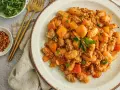 Délicieux sauté boeuf haché asiatique avec des gnocchis et des morceaux de carottes, garni de persil frais.