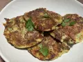 Galettes dorées de courgette et pomme de terre, garnies de persil frais, prêtes à être dégustées.