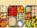 Une recette bento colorée et équilibrée : riz, fraises, crudités, sandwich, rouleaux de printemps, fruits et légumes variés.