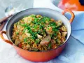 Un plat de jambalaya coloré, garni de crevettes, poulet, saucisse et oignons verts. Une recette savoureuse à découvrir.