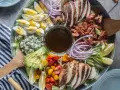 Salade généreuse avec poulet grillé, bacon croustillant, œufs durs, avocat, tomates cerises, oignons rouges et fromage bleu. Une salade kobe parfaite pour un repas complet.