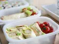 Sandwichs et tomates cerises dans une boîte, une idée de recette lunch box facile et rapide pour un repas sain.