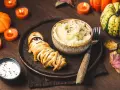 Un délicieux menu d'Halloween pour adultes : une momie feuilletée, purée de pommes de terre et sauce crémeuse, le tout dans une ambiance tamisée par des bougies.