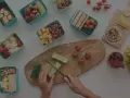 Préparation d'un panier repas travail de nuit : fruits, légumes, sandwichs, œufs, fromage et noix.