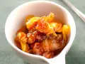 Chutney de prunes, un délice sucré-salé aux fruits confits et noix, servi dans un bol blanc.