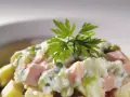 Une délicieuse salade piémontaise crémeuse, garnie de persil frais.