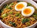 Un bol de ramen sauté garni d'œufs mollets, d'oignons verts et de graines de sésame. Un plat savoureux et réconfortant.