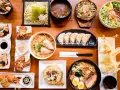 Un festin de nourriture japonaise nom : ramen, tempura, gyoza, riz frit et plus encore, prêt à être dégusté.