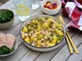 Salade strasbourgeoise appétissante avec pommes de terre, saucisse en dés, cornichons et persil frais. Un délice alsacien !