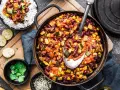 Un plat de chili végétarien copieux avec des haricots rouges, du maïs et des courgettes, servi avec du riz blanc.