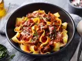 Pâtes larges nappées d'une riche sauce à la palette de boeuf effilochée, parsemées de parmesan et de persil frais.