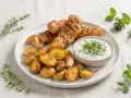 Brochettes de porc grillées, pommes de terre rôties et sauce crémeuse aux herbes. Un délice de marinade porc.