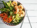 Un poke bowl crevette facile et coloré avec avocat, carottes spirales, courgettes en nouilles et pois gourmands.