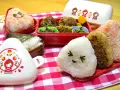 Un joyeux repas avec des onigiri crevette et d'autres délices dans des boîtes bento colorées.