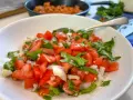 Un bol de pico de gallo frais, garni de coriandre, prêt à être dégusté.