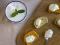 Un bol de crème tzatziki frais, garni de menthe, est servi avec des toasts.