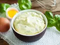 Mayonnaise onctueuse au basilic, avec un œuf et des feuilles de basilic frais.