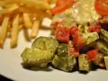 Une délicieuse salade de cornichon avec des tomates et des herbes, accompagnée de frites croustillantes.