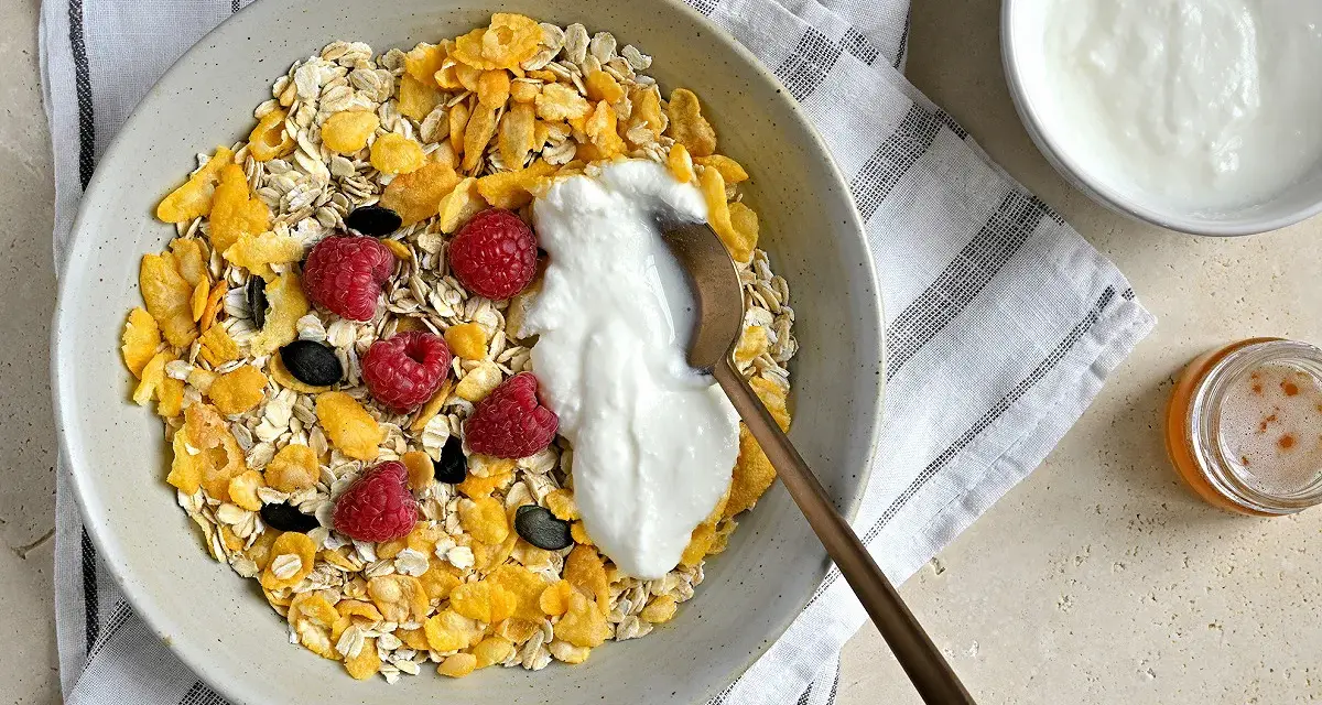 Un bol de céréales, flocons d'avoine, framboises et fromage blanc. Une recette saine et gourmande pour le petit-déjeuner.
