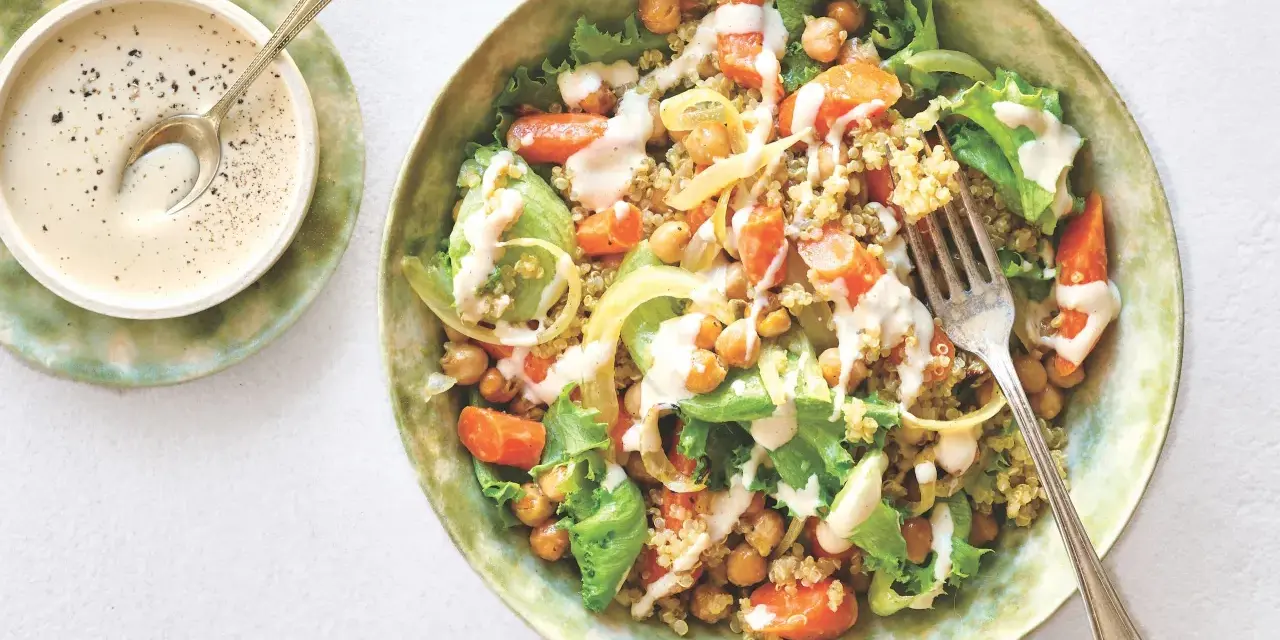 Salade colorée de quinoa, pois chiches, carottes et laitue, arrosée d'une sauce crémeuse. Une recette healthy simple et savoureuse.