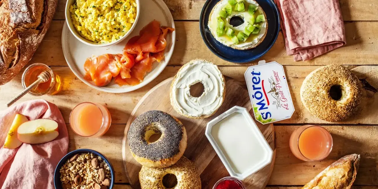 Un festin pour le déjeuner : œufs brouillés, saumon fumé, bagels, fromage frais, jus et fruits. Qu'est-ce qu'on mange à midi ?