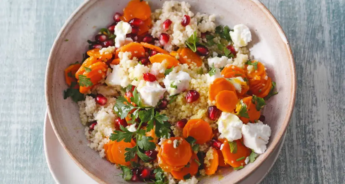 Salade de semoule colorée avec carottes, grenade et morceaux de feta. Un délice frais et savoureux.