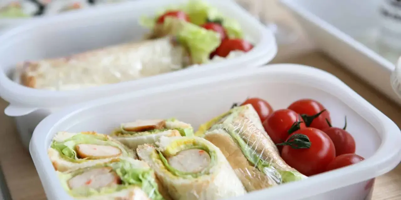 Sandwichs et tomates cerises dans une boîte, une idée de recette lunch box facile et rapide pour un repas sain.