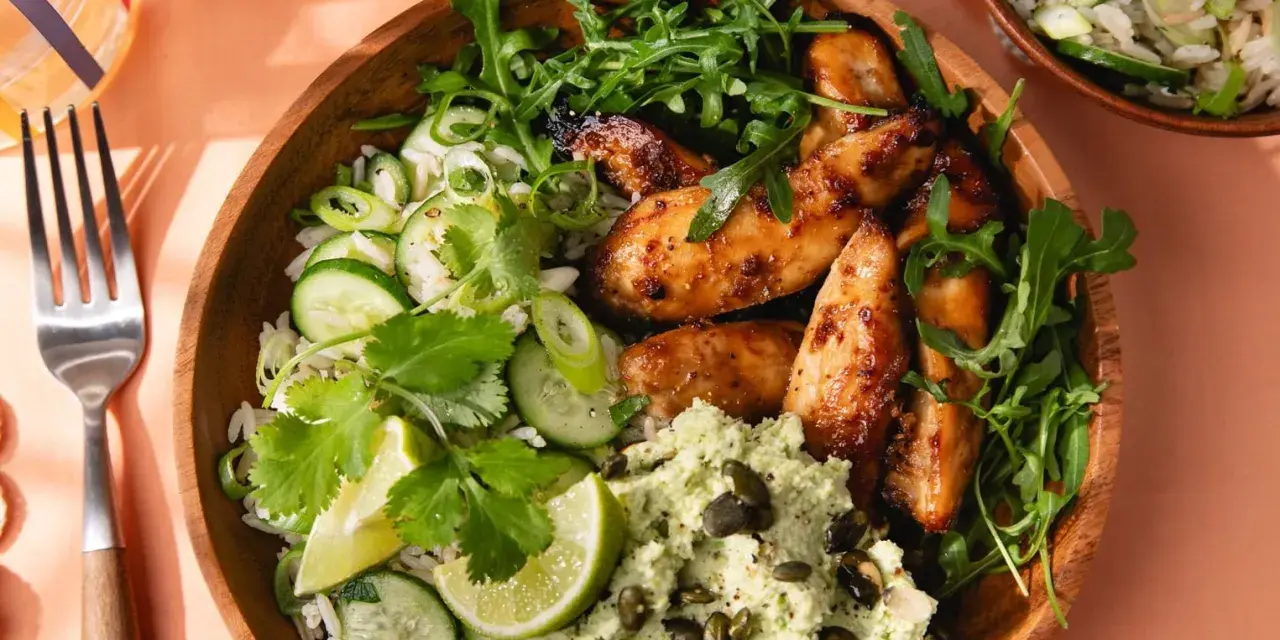 Un bol de riz avec poulet laqué, concombre, coriandre et une purée verte. Une délicieuse recette asiatique healthy.