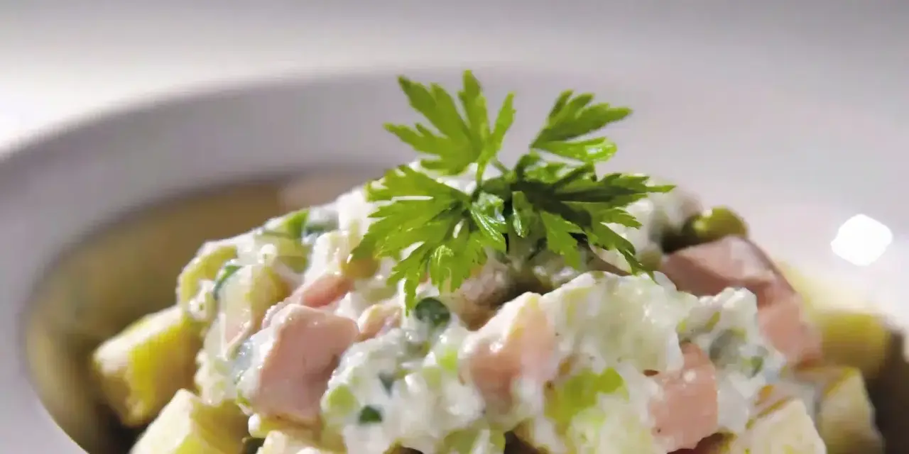 Une délicieuse salade piémontaise crémeuse, garnie de persil frais.