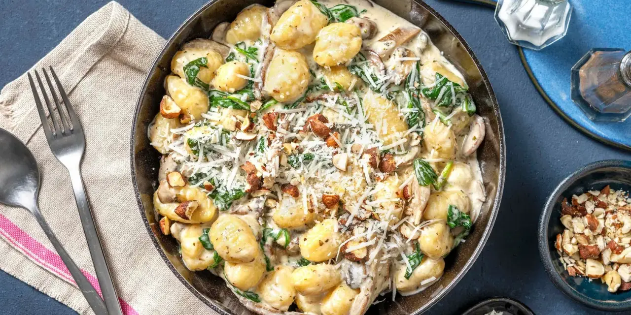 Gnocchi crémeux aux champignons, épinards et noix, saupoudrés de parmesan. Un délice réconfortant.
