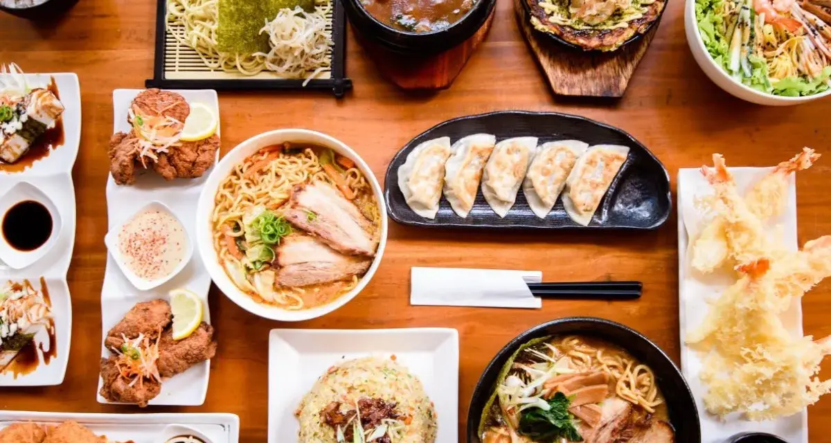 Un festin de nourriture japonaise nom : ramen, tempura, gyoza, riz frit et plus encore, prêt à être dégusté.