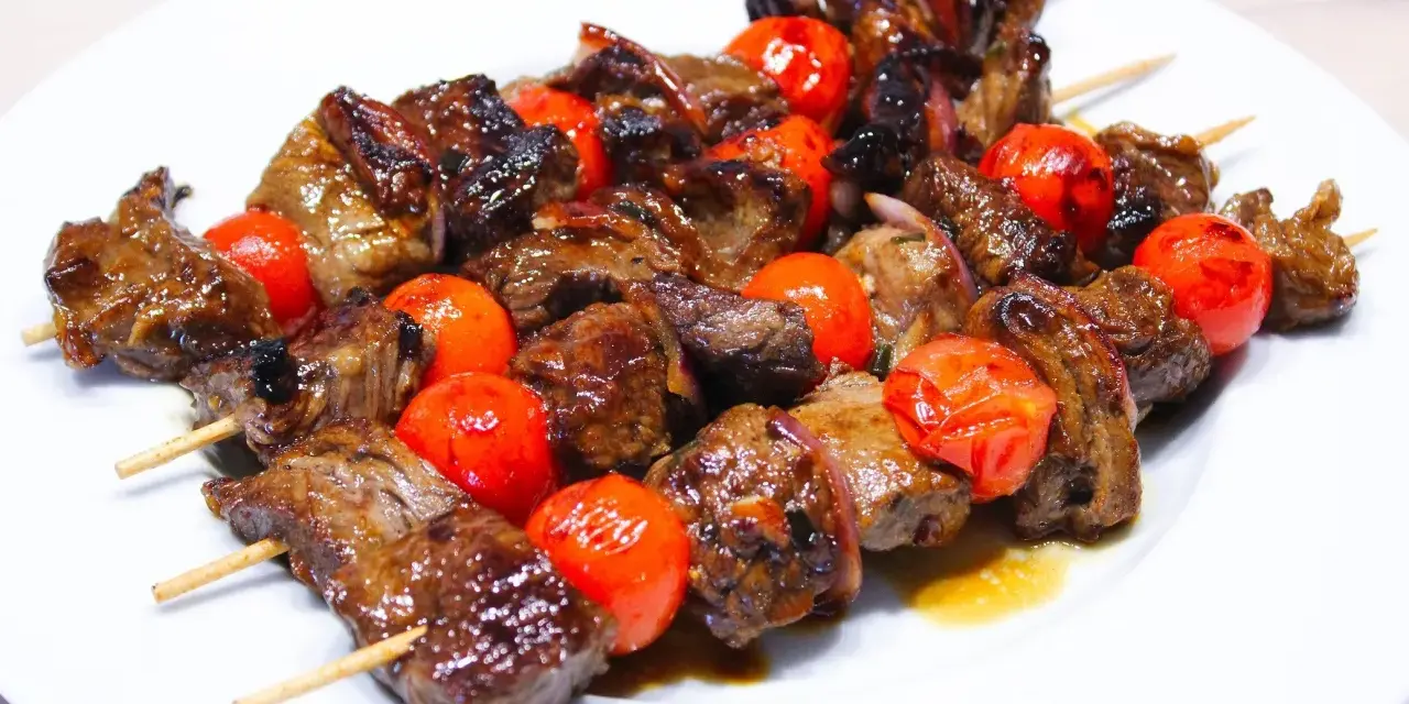 Brochettes de bœuf juteuses et grillées, alternant avec des tomates cerises éclatantes. La meilleure marinade brochette boeuf pour un goût inoubliable.
