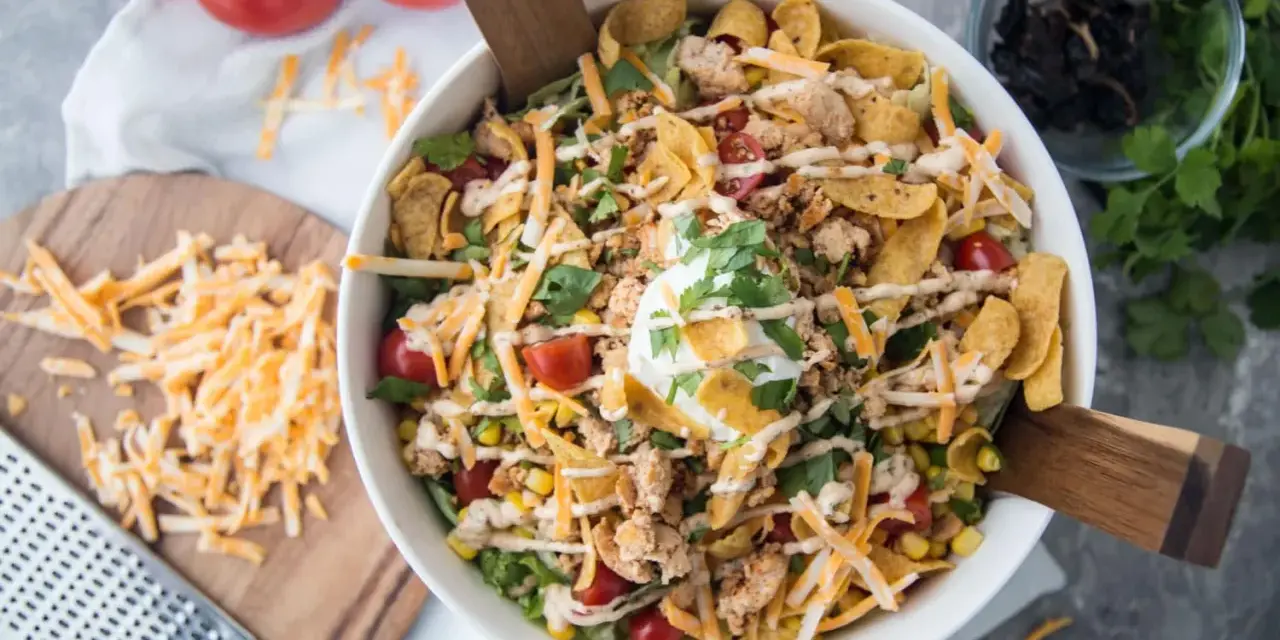 Salade Tex Mex généreuse avec poulet émietté, maïs, tomates cerises, fromage râpé, éclats de tortilla et une touche de crème. Parfait pour un repas plein de saveurs.