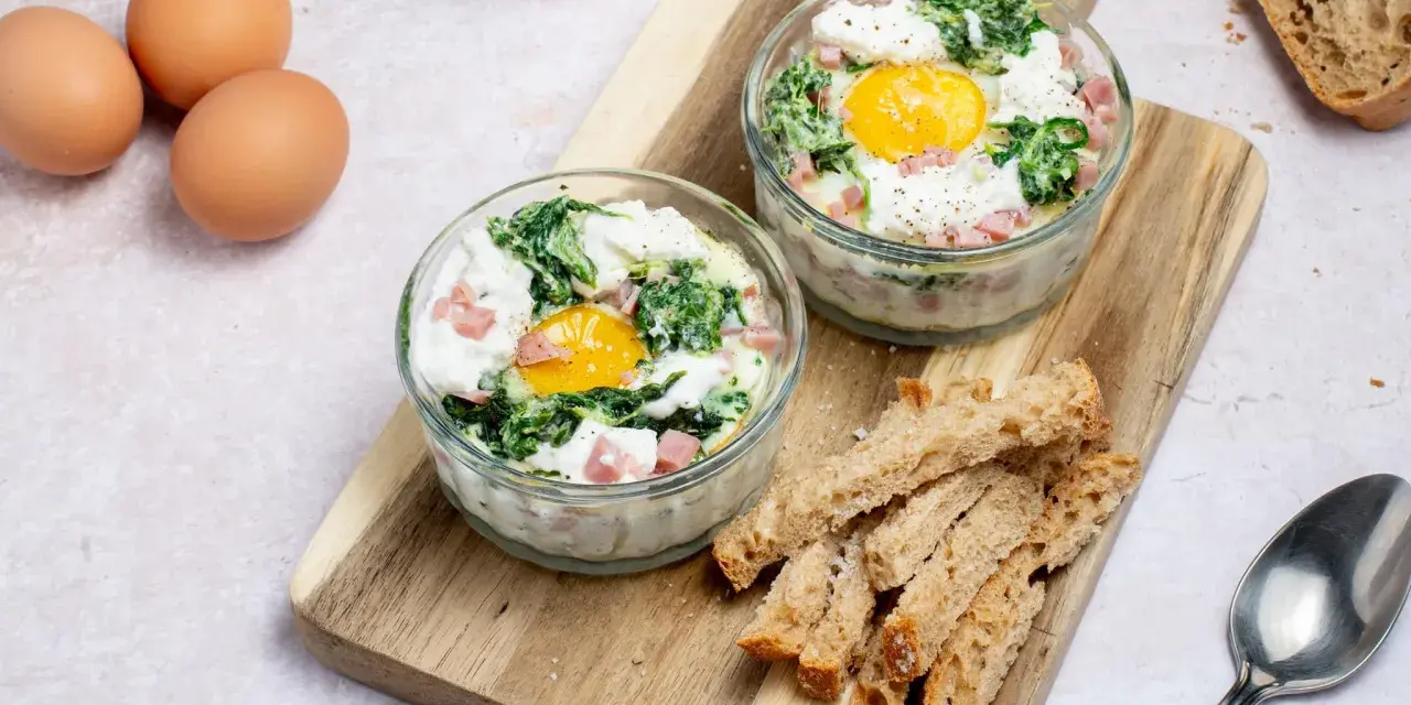Œufs cocotte aux épinards et dés de jambon, une recette facile pour le midi. Servis avec des mouillettes de pain grillé.