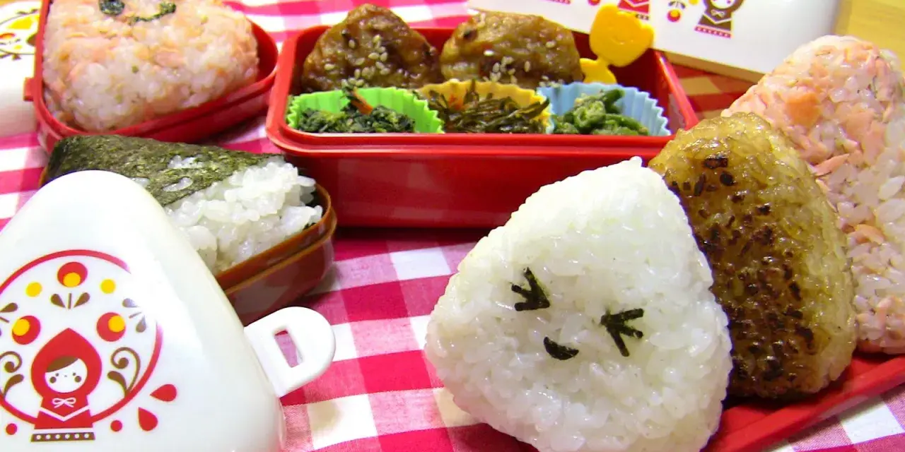 Un joyeux repas avec des onigiri crevette et d'autres délices dans des boîtes bento colorées.