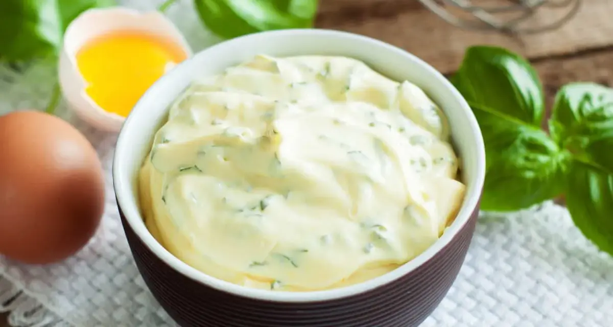 Mayonnaise onctueuse au basilic, avec un œuf et des feuilles de basilic frais.