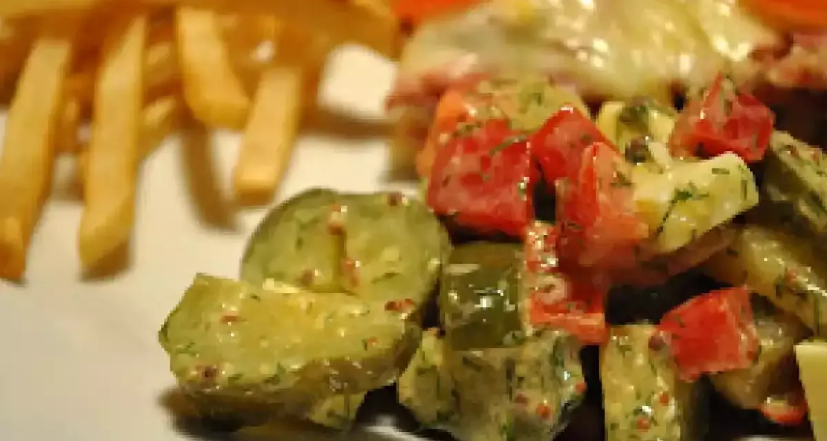 Une délicieuse salade de cornichon avec des tomates et des herbes, accompagnée de frites croustillantes.