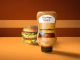 Bouteille de sauce Big Mac en édition limitée à côté d'un Big Mac. La sauce a un design inspiré du burger.