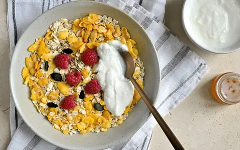 Un bol de céréales, flocons d'avoine, framboises et fromage blanc. Une recette saine et gourmande pour le petit-déjeuner.