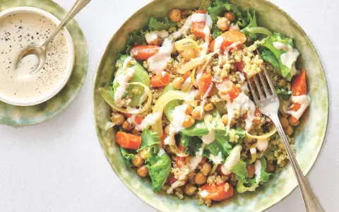 Salade colorée de quinoa, pois chiches, carottes et laitue, arrosée d'une sauce crémeuse. Une recette healthy simple et savoureuse.