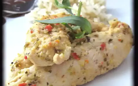 Un délicieux poulet avec une marinade poulet grec, garni d'herbes fraîches et servi avec du riz.
