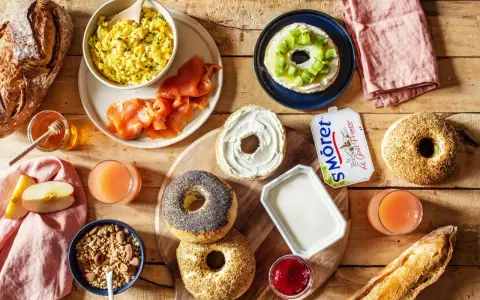 Un festin pour le déjeuner : œufs brouillés, saumon fumé, bagels, fromage frais, jus et fruits. Qu'est-ce qu'on mange à midi ?