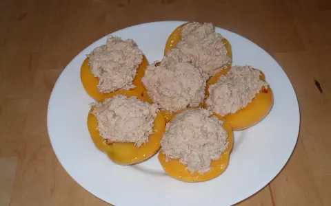 Moitié de pêches garnies d'une préparation de thon, prêtes pour un apéritif original. Une recette de pêche au thon revisitée.