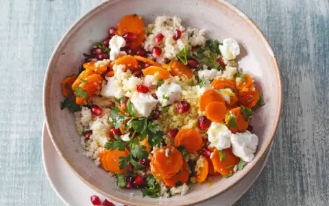 Salade de semoule colorée avec carottes, grenade et morceaux de feta. Un délice frais et savoureux.