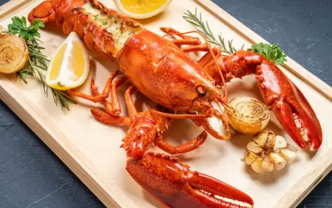 Homard entier, prêt pour la cuisson, garni de citron, d'oignons grillés et d'ail. Un délice pour les amateurs de fruits de mer.