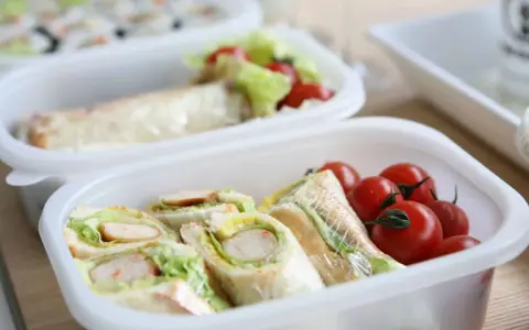 Sandwichs et tomates cerises dans une boîte, une idée de recette lunch box facile et rapide pour un repas sain.