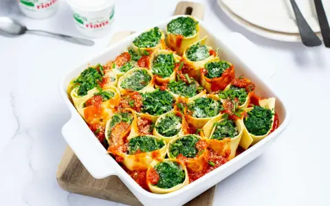 Cannellonis farcis aux épinards et ricotta, nappés de sauce tomate. Une délicieuse recette pas cher, parfaite pour un repas convivial.